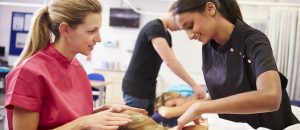 A NYIM massage therapy program instructor teaches a student in Williamsville, NY